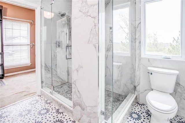 full bathroom with plenty of natural light, toilet, a marble finish shower, and tile patterned floors