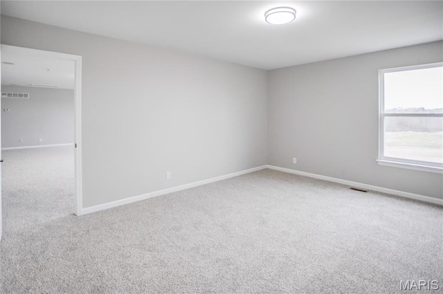 empty room featuring carpet flooring and baseboards