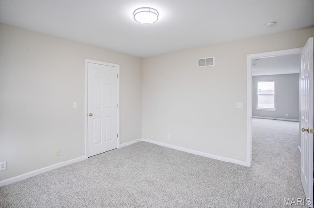 carpeted spare room featuring baseboards and a smoke detector