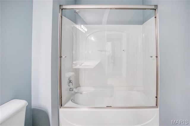 bathroom with toilet and combined bath / shower with glass door