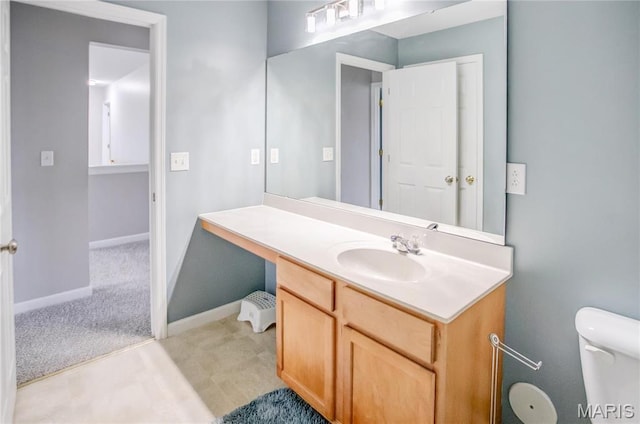 bathroom featuring vanity, baseboards, and toilet