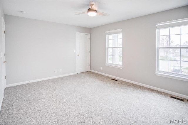 empty room with a ceiling fan, baseboards, and carpet flooring