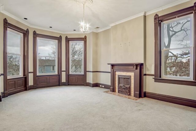 unfurnished living room featuring carpet floors, crown molding, a chandelier, a fireplace with flush hearth, and baseboards