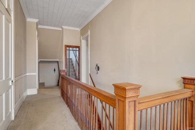 hallway with an upstairs landing, crown molding, and light colored carpet
