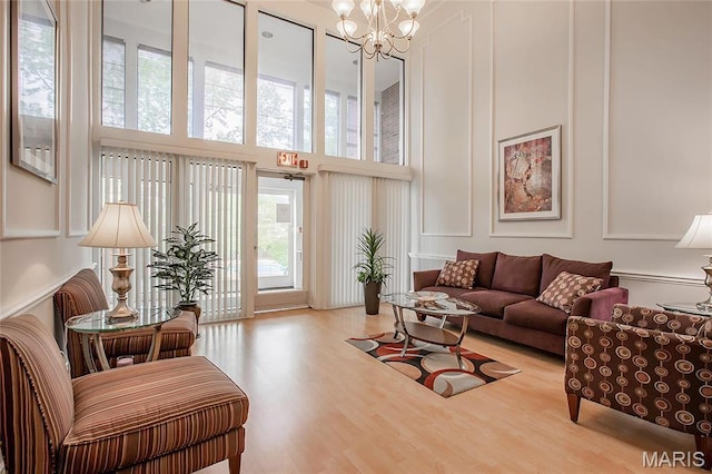 585 Coeur De Royale Dr Unit 206, Creve Coeur, MO 63141 - living room with a high ceiling, wood finished floors, a chandelier, and a decorative wall