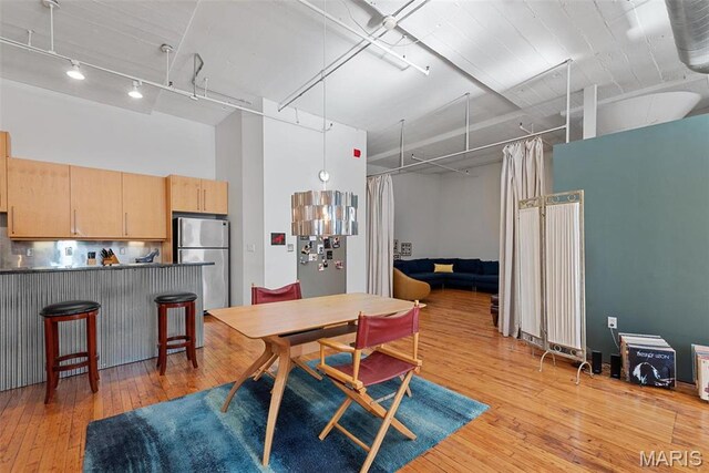1010 Saint Charles St Unit 904, Saint Louis, MO 63101 - dining space with light wood finished floors, track lighting, and a towering ceiling