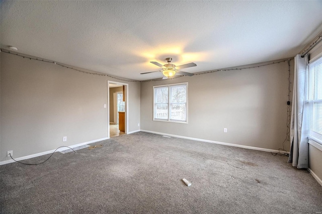 1311 Beck, Lebanon, MO 65536 - empty room with plenty of natural light, ceiling fan, carpet flooring, baseboards, and a textured ceiling