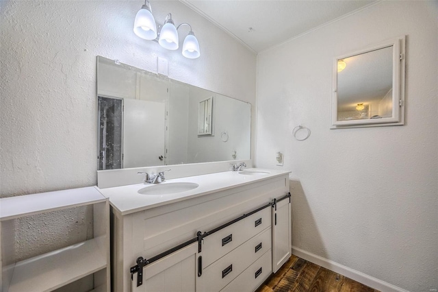 1311 Beck, Lebanon, MO 65536 - bathroom featuring wood finished floors, double vanity, baseboards, and a textured wall