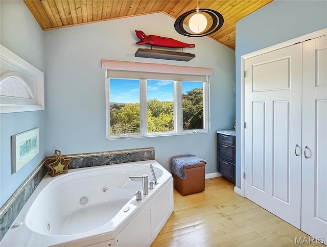 501 4th St W, Hermann, MO 65041 - bathroom featuring wooden ceiling, vaulted ceiling, a tub with jets, and wood finished floors