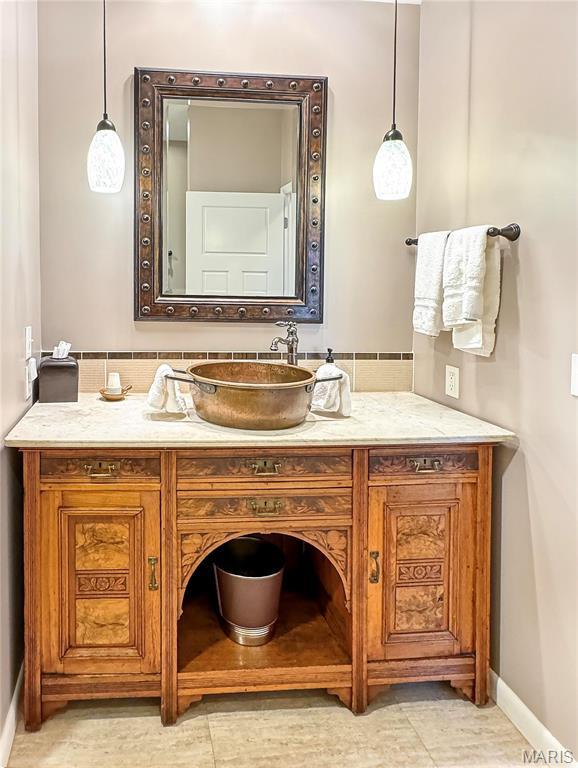 501 4th St W, Hermann, MO 65041 - bathroom with baseboards, vanity, and tasteful backsplash