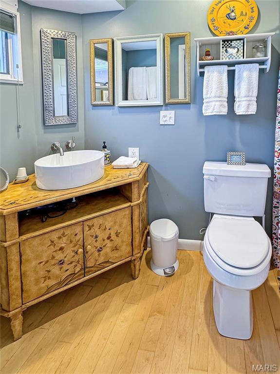 501 4th St W, Hermann, MO 65041 - bathroom featuring toilet, wood finished floors, vanity, and baseboards
