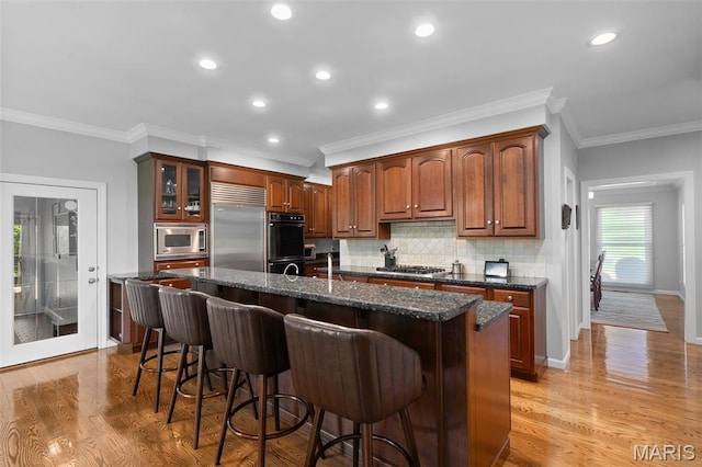 29 Spoede Ln, Creve Coeur, MO 63141 - kitchen featuring built in appliances, a breakfast bar area, tasteful backsplash, an island with sink, and recessed lighting