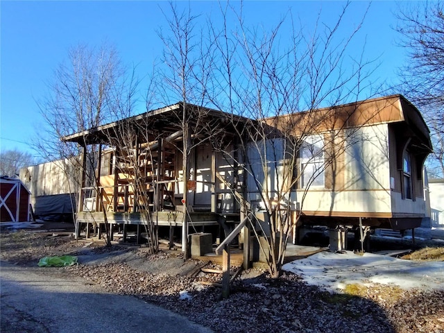rear view of property featuring a wooden deck