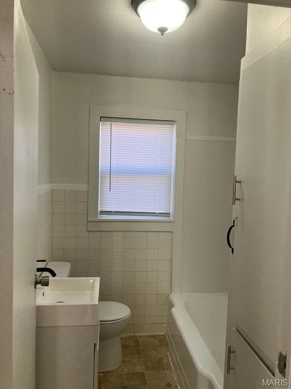 full bathroom with toilet, vanity, tile walls, and tile patterned flooring