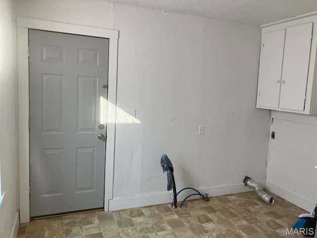 washroom with cabinet space and baseboards