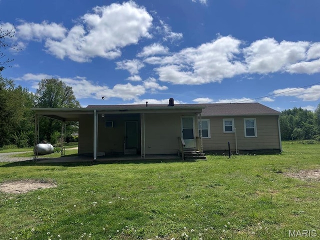 back of house with a lawn and entry steps