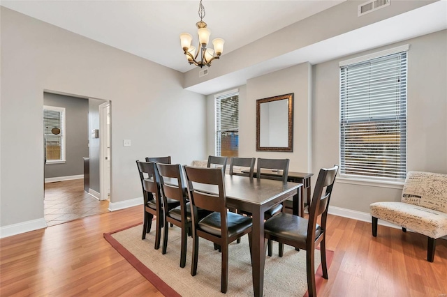 4125 Chouteau Ave, Saint Louis, MO 63110 - dining space featuring a chandelier, plenty of natural light, baseboards, and light wood-type flooring