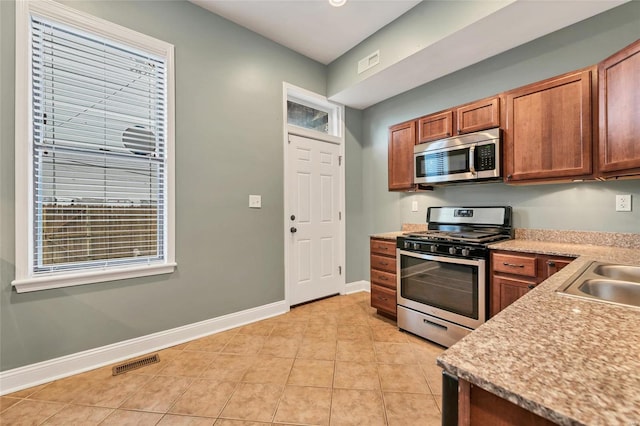 4125 Chouteau Ave, Saint Louis, MO 63110 - kitchen with appliances with stainless steel finishes, baseboards, light countertops, and light tile patterned flooring