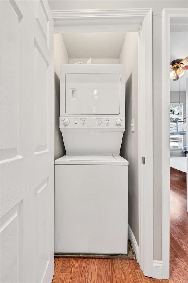 4125 Chouteau Ave, Saint Louis, MO 63110 - laundry room featuring estacked washer and dryer, light wood finished floors, and a ceiling fan