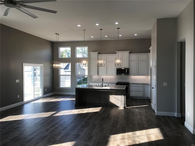 1605 Sugar Creek Dr, Festus, MO 63028 - kitchen featuring stainless steel microwave, open floor plan, recessed lighting, baseboards, and dark wood finished floors