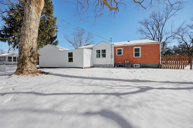 17 S Floridale Dr, Saint Louis, MO 63135 - snow covered rear of property featuring brick siding, central AC unit, and fence