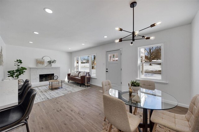 17 S Floridale Dr, Saint Louis, MO 63135 - dining room featuring wood finished floors, a chandelier, baseboards, recessed lighting, and a fireplace with raised hearth