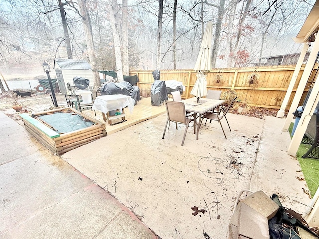 10063 Mockingbird Dr, Holiday Shores, MO 63624 - view of patio featuring a fenced backyard, outdoor dining space, a storage shed, a deck, and an outdoor structure