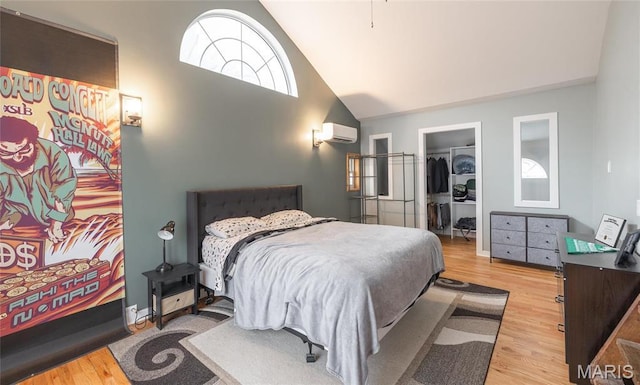 801 E 14th St, Rolla, MO 65401 - bedroom featuring an AC wall unit, wood finished floors, a spacious closet, a closet, and high vaulted ceiling