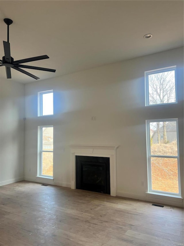 1066 Bloomfield Dr, Eureka, MO 63025 - unfurnished living room featuring a towering ceiling, a fireplace, wood finished floors, and baseboards
