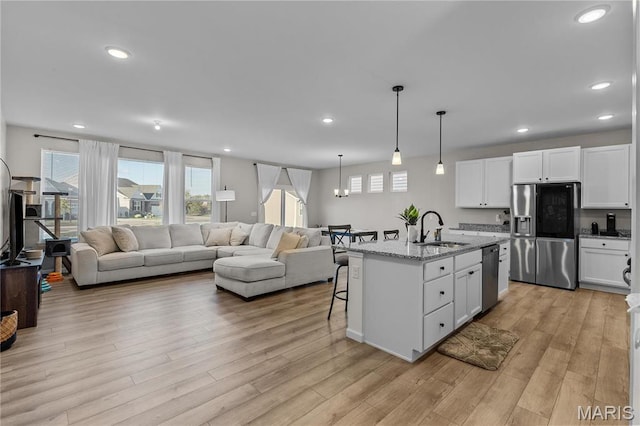 138 Rhythm Point Dr, Saint Peters, MO 63376 - kitchen with appliances with stainless steel finishes, a sink, healthy amount of natural light, a kitchen bar, and recessed lighting