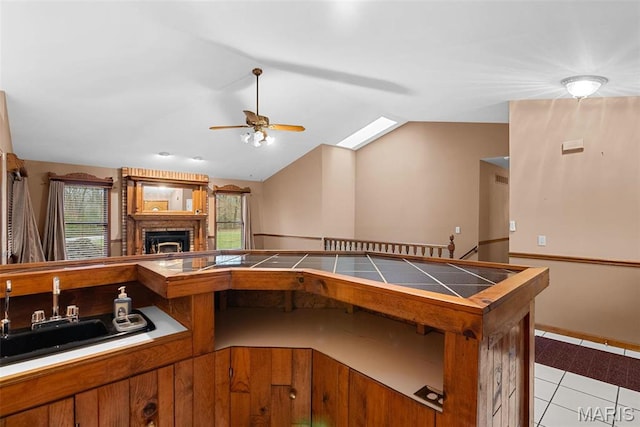 23 Falling Leaf Dr, Lake St Louis, MO 63367 - kitchen with tile countertops, a sink, a ceiling fan, lofted ceiling, and brown cabinetry