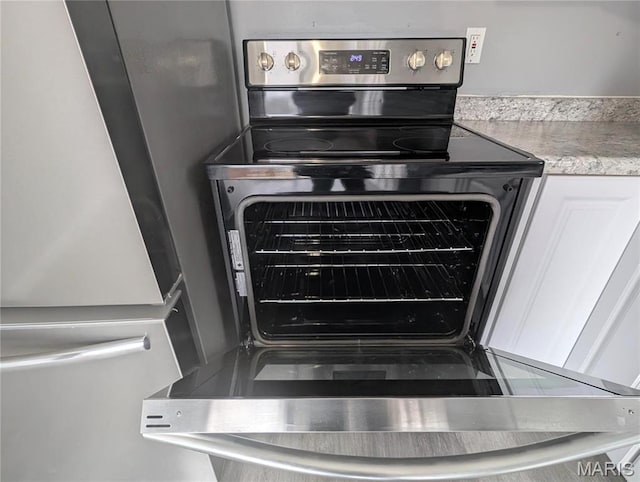 10544 Decker Ave, Saint Louis, MO 63114 - kitchen view of appliances with stainless steel finishes, light countertops, and white cabinetry