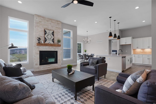1035 Morgan Meadow Dr, Wentzville, MO 63385 - living area with a ceiling fan, light wood-type flooring, recessed lighting, a chandelier, and a stone fireplace