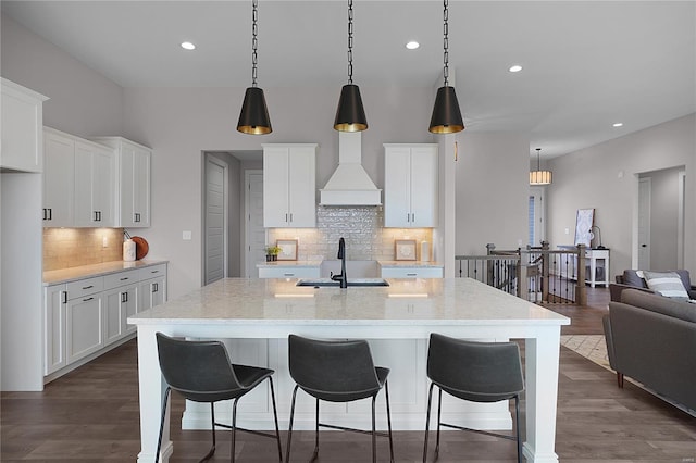 1035 Morgan Meadow Dr, Wentzville, MO 63385 - kitchen with a sink, custom exhaust hood, decorative backsplash, a breakfast bar, and recessed lighting