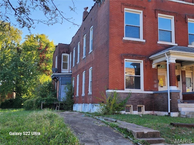 view of side of property with brick siding and a chimney