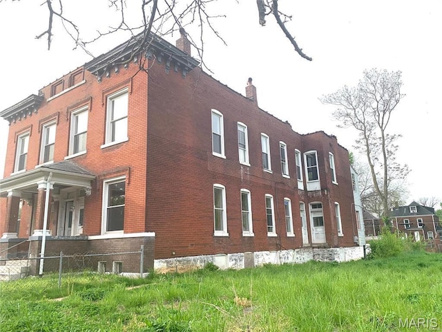 view of property exterior with brick siding and a chimney