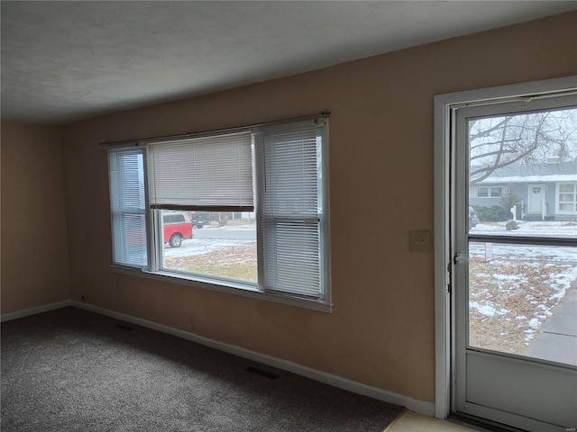 doorway with plenty of natural light, baseboards, and light colored carpet