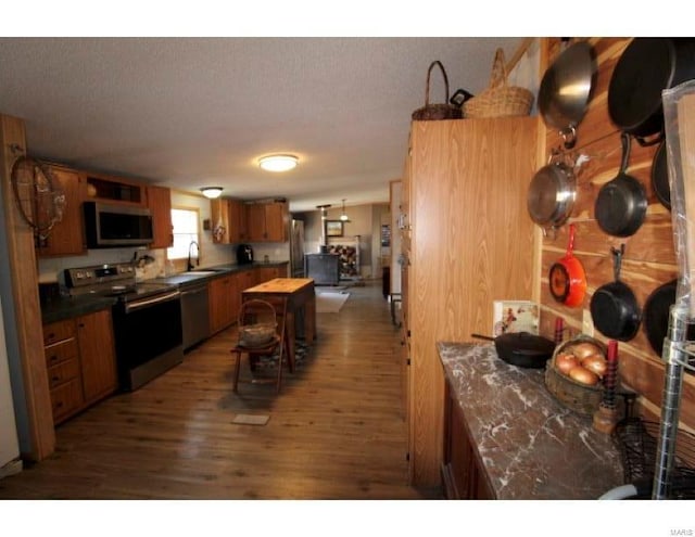 2086 County Road 137, Wasola, MO 65773 - kitchen featuring appliances with stainless steel finishes, dark countertops, wood finished floors, brown cabinets, and a textured ceiling