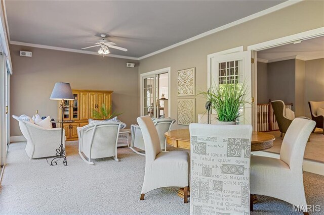 carpeted dining area featuring ceiling fan, ornamental molding, and plenty of natural light