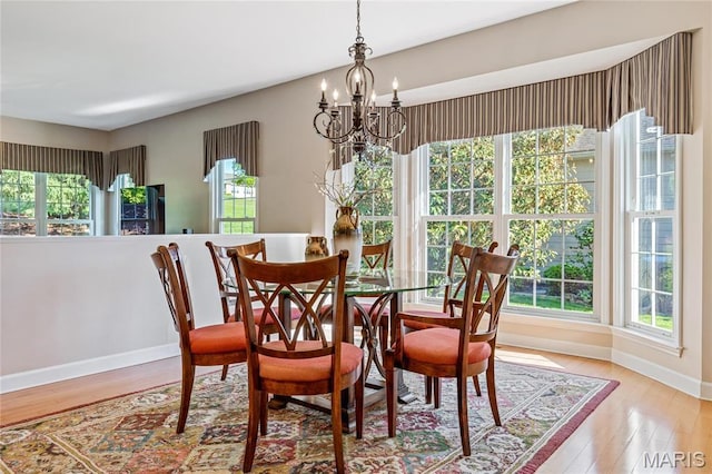 dining area featuring a chandelier, baseboards, and plenty of natural light