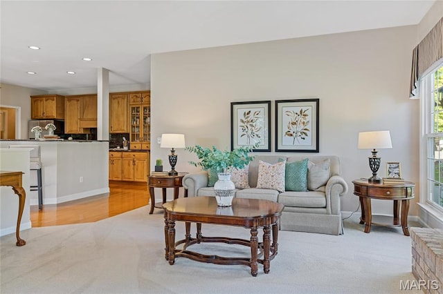 living room featuring light carpet, recessed lighting, and baseboards