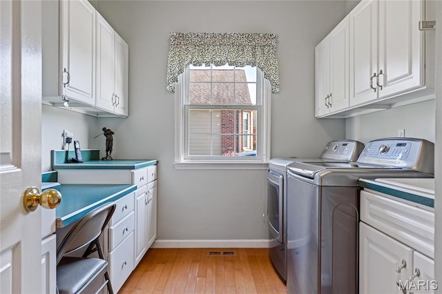 laundry room with separate washer and dryer, cabinet space, light wood finished floors, baseboards, and an office area