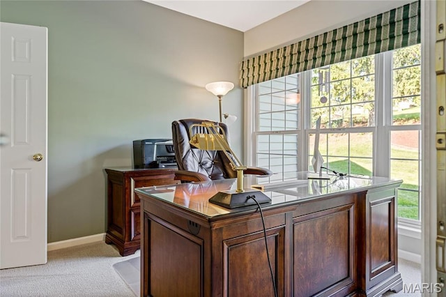 office area featuring light carpet, healthy amount of natural light, and baseboards