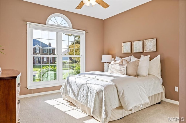 carpeted bedroom with baseboards and a ceiling fan