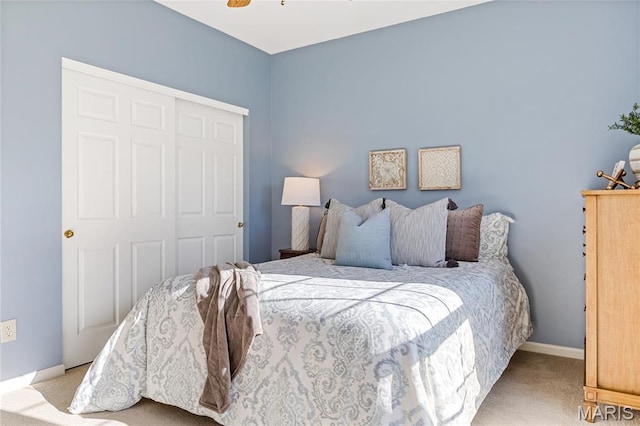bedroom with carpet flooring, a closet, baseboards, and ceiling fan