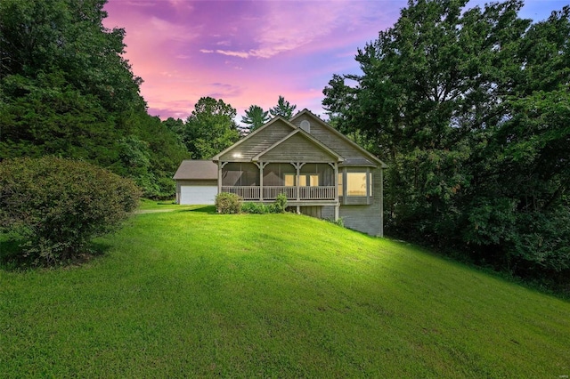 view of front of property with a front yard and a detached garage