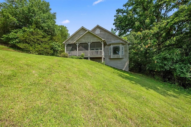 back of house with a yard and a sunroom