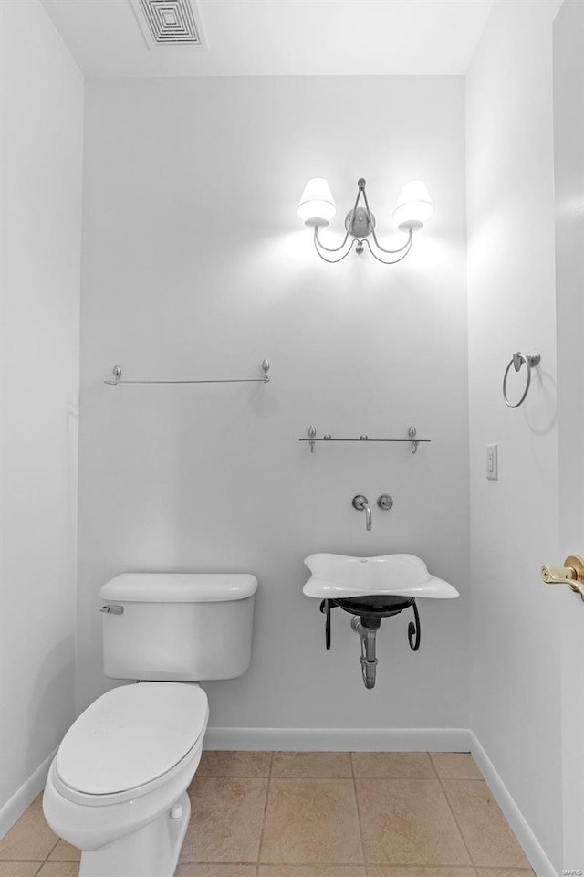 bathroom with toilet, baseboards, and tile patterned floors