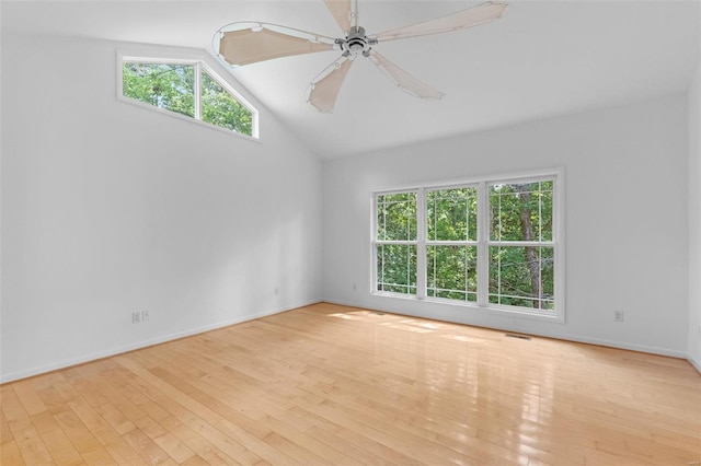 unfurnished room with healthy amount of natural light, hardwood / wood-style flooring, ceiling fan, baseboards, and high vaulted ceiling