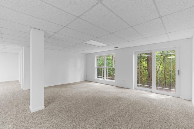 unfurnished living room with carpet, a paneled ceiling, and baseboards